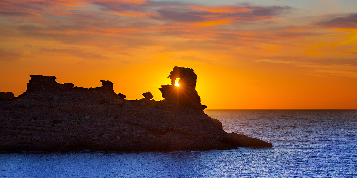 El atardecer destrás de las rocas desde la Cala Morell es probablemente el más bonito de la isla de Menorca