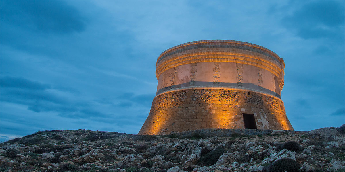 Esta torre de defensa fue costera de forma troncocónica construida por los ingleses a principios del siglo XIX con la intención de vigilar la entrada al puerto de Fornells e impedir desembarcos enemigos