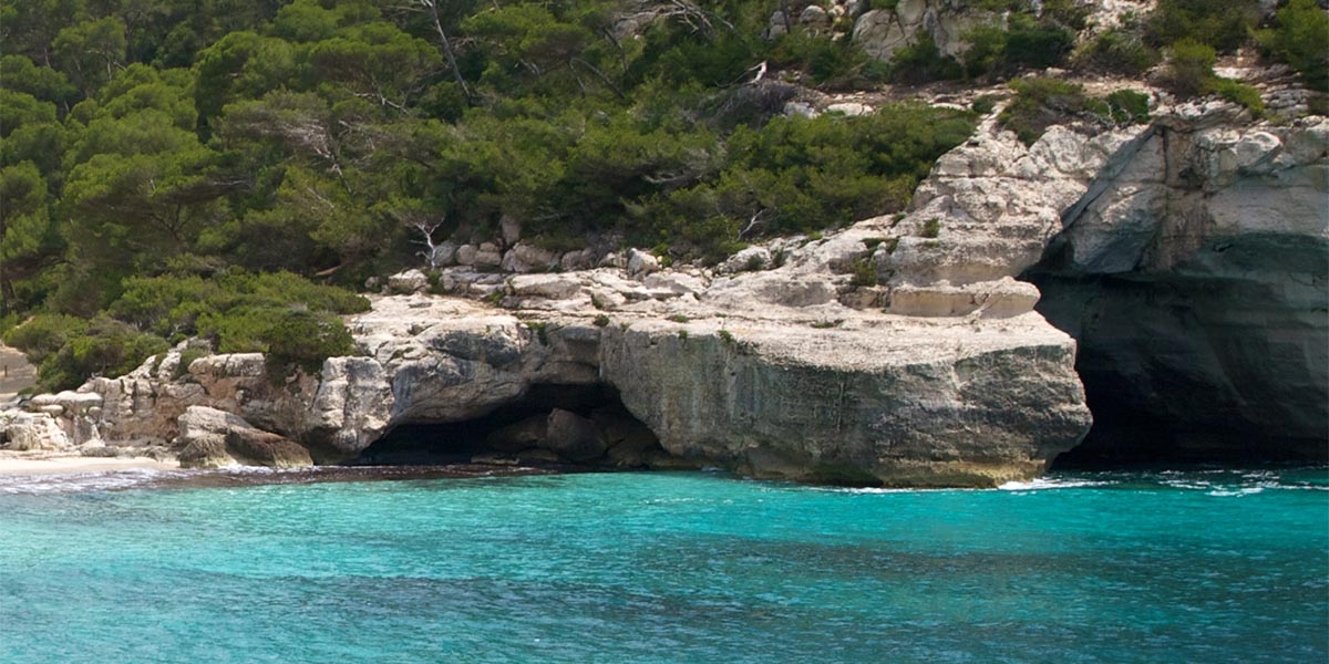 Menorca se encuantra rodeada de pequeñas cuevas en sus acantilados que puedes visitar desde una embarcación